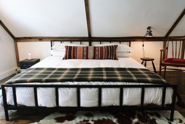 Warner's camp Adirondack cabin rental vacation lake placid king bed kilim lumbar pillow pendleton plaid blanket